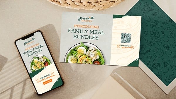 A piece of Greenville Market direct mail entices customers with “FAMILY MEAL BUNDLES.” Its digital counterpart sits next to it on a phone screen.