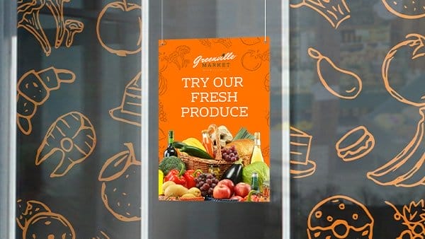 A Greenville Market sign made of P V C hangs in a window encouraging customers to “TRY OUR FRESH PRODUCE.”