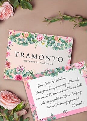 A branded note card is surrounded by flowers.