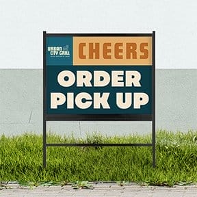 A yard sign in the grass directs customers to 'ORDER PICK UP.'