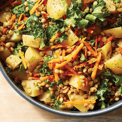 Kale and Lentil Salad with Potatoes in a gray ceramic bowl against a light wood tabletop