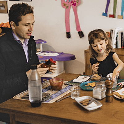 A father and daughter sit at the dinner table