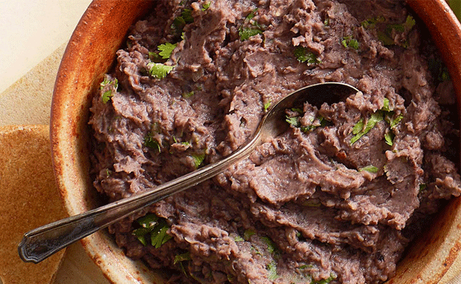 Chipotle Black Bean Dip in a terracotta bowl with a silver teaspoon