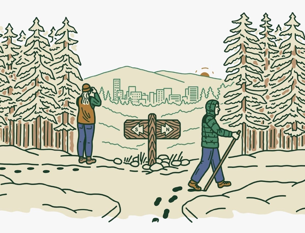 At a trailhead, a woman peers through binoculars at a city in the distance while a man wearing a puffy jacket hikes along a trail