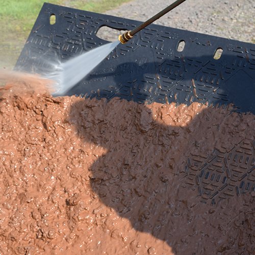 pressure washing dirt off ground protection mat