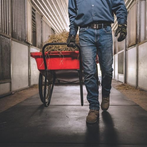 wheelbarrow and man walking on straight edge barn aisle mats