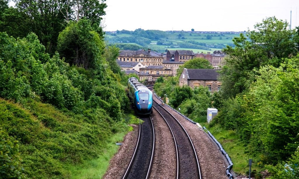 Train on railway passing a town and trees