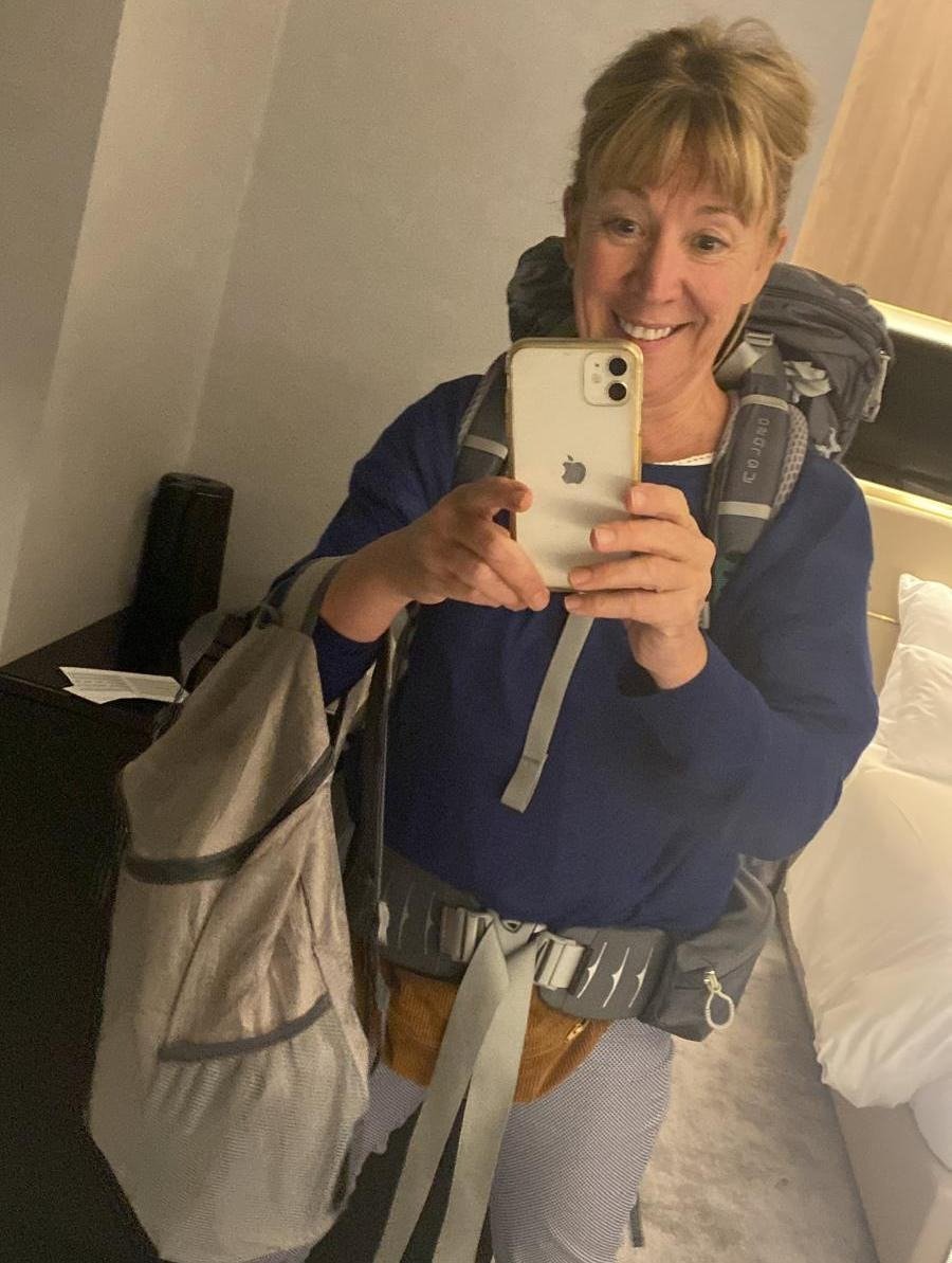 Sam in a hotel room wearing a backpack