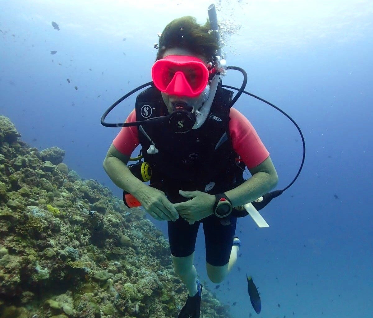 Sam underwater wearing scuba gear, surrounded by fish