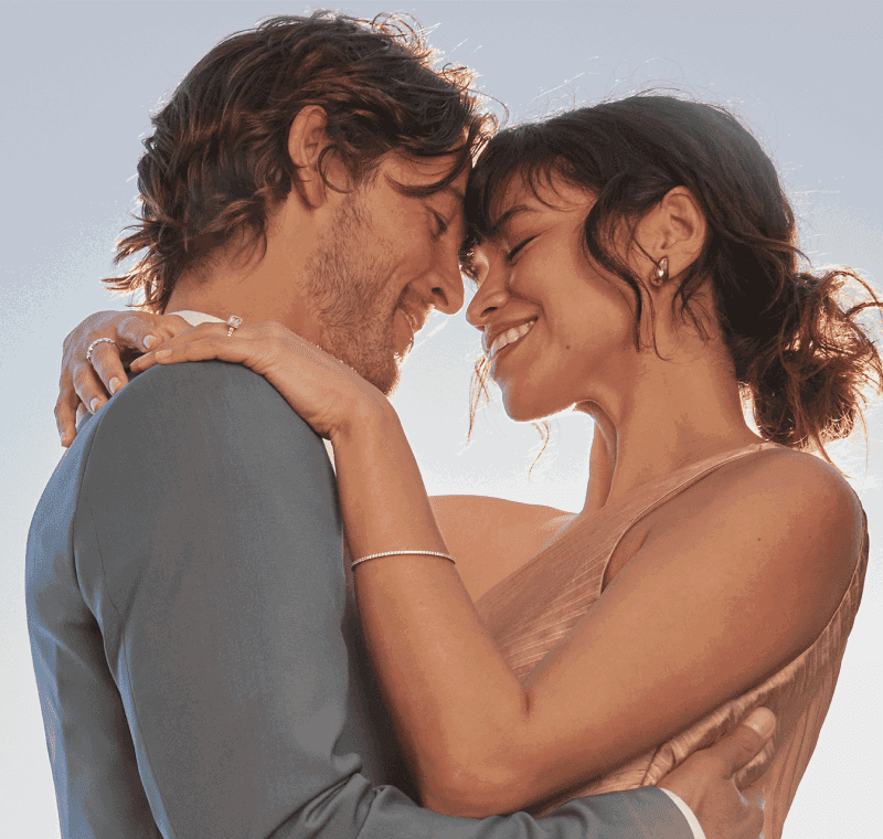 A couple sharing a warm embrace, wearing gold and silver beautiful jewellery