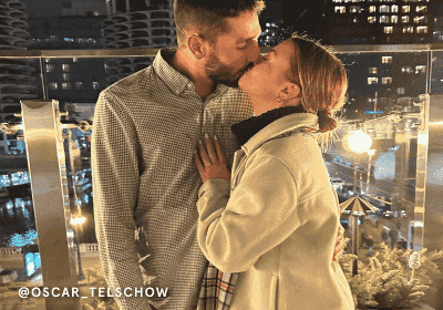 A Couple embrace, showcasing stunning rings and earrings.