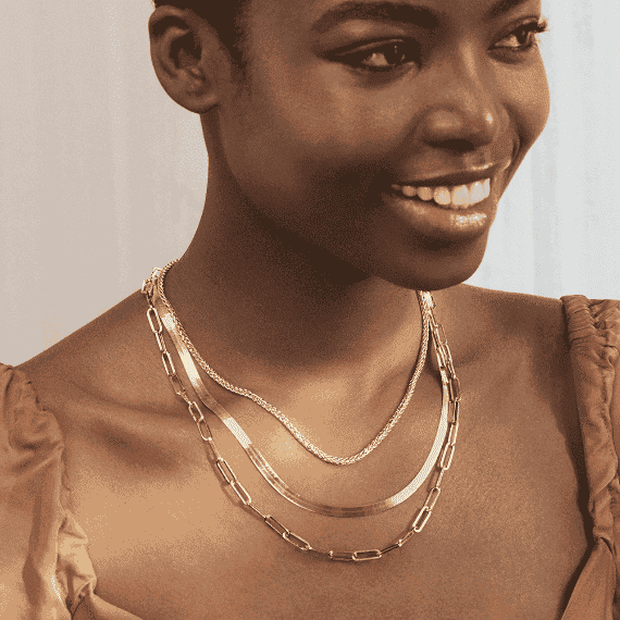 A couple share an affectionate moment. Assorted women's jewelry is visible, including a earrings, necklace, and ring.