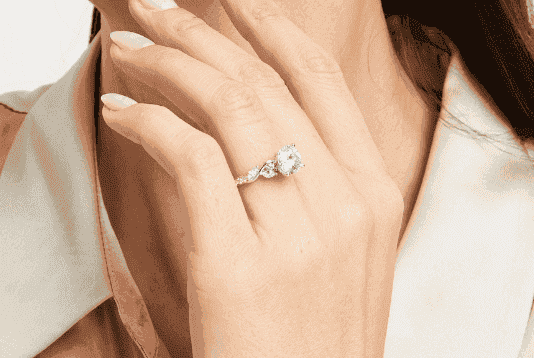 Close up of a woman's hand, with diamond ring prominently displayed.