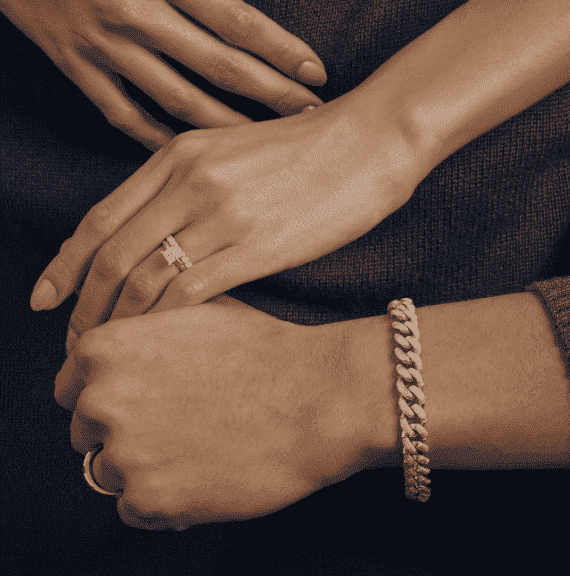 Two hands showcasing various rings and a bracelet.