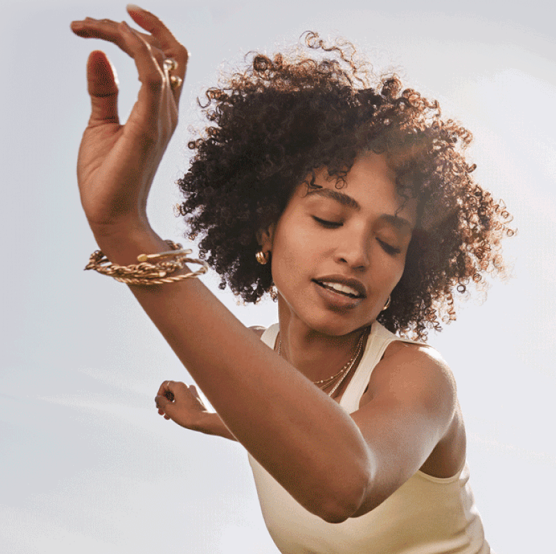 A dancing woman adorned with golden bracelets and necklaces.