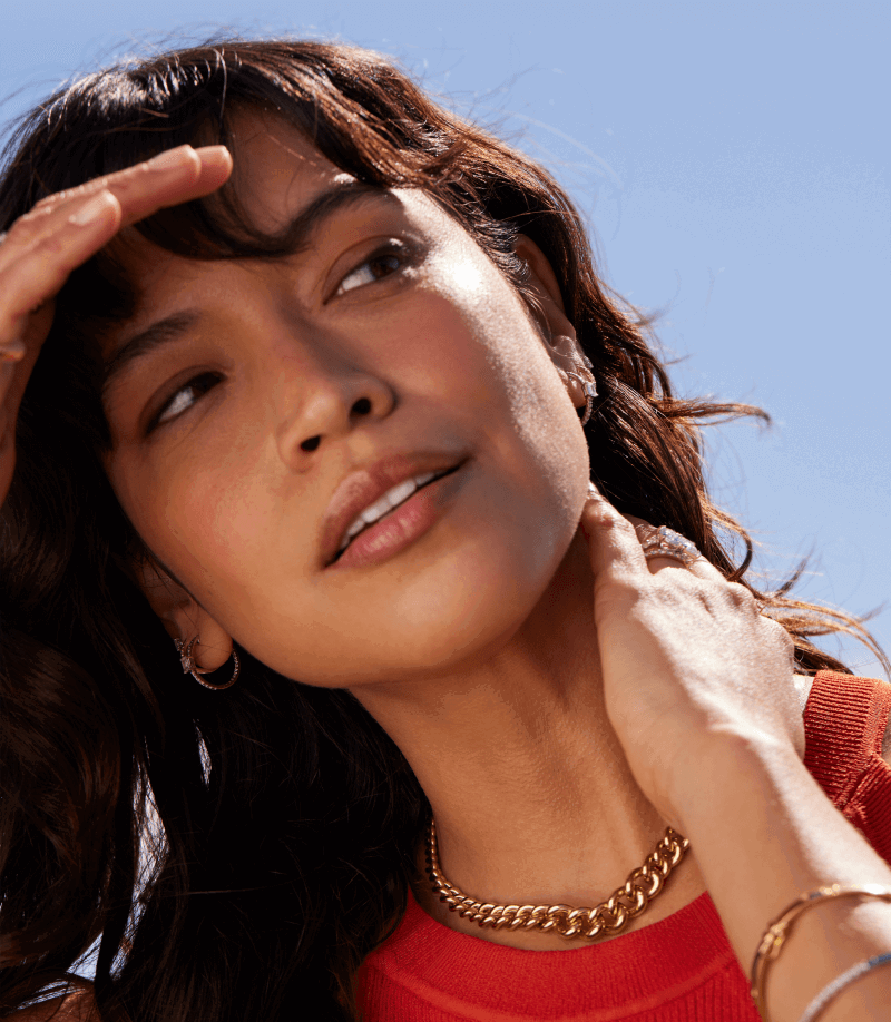 A woman wearing a gold chain around her neck.