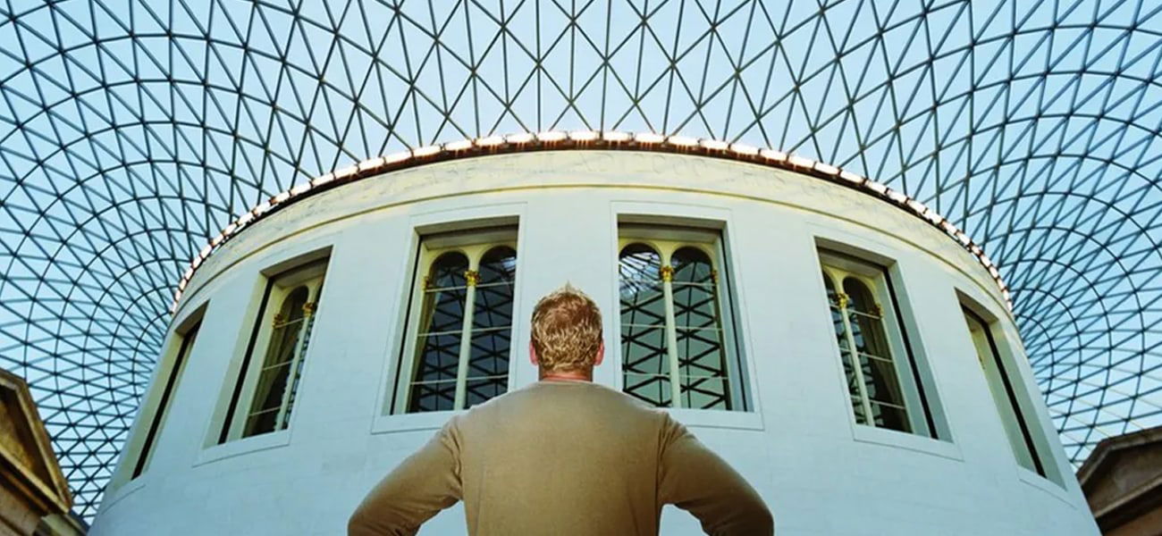 A person standing under glass roof, The British Museum, London, England.