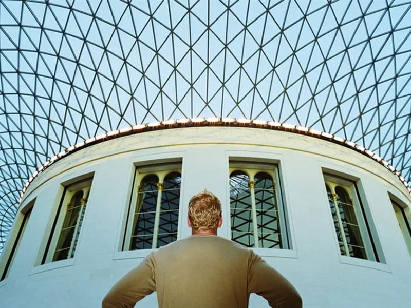 A person standing under glass roof, The British Museum, London, England.