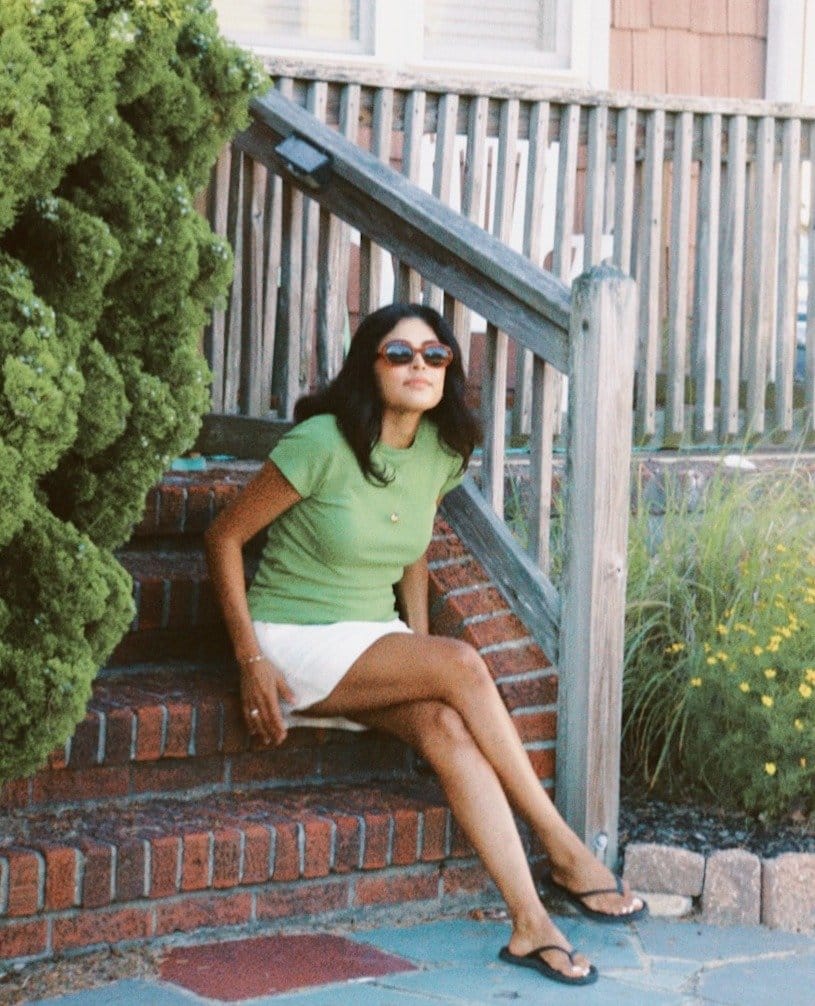 Wistful Woman wears white mini skirt with green baby tee.