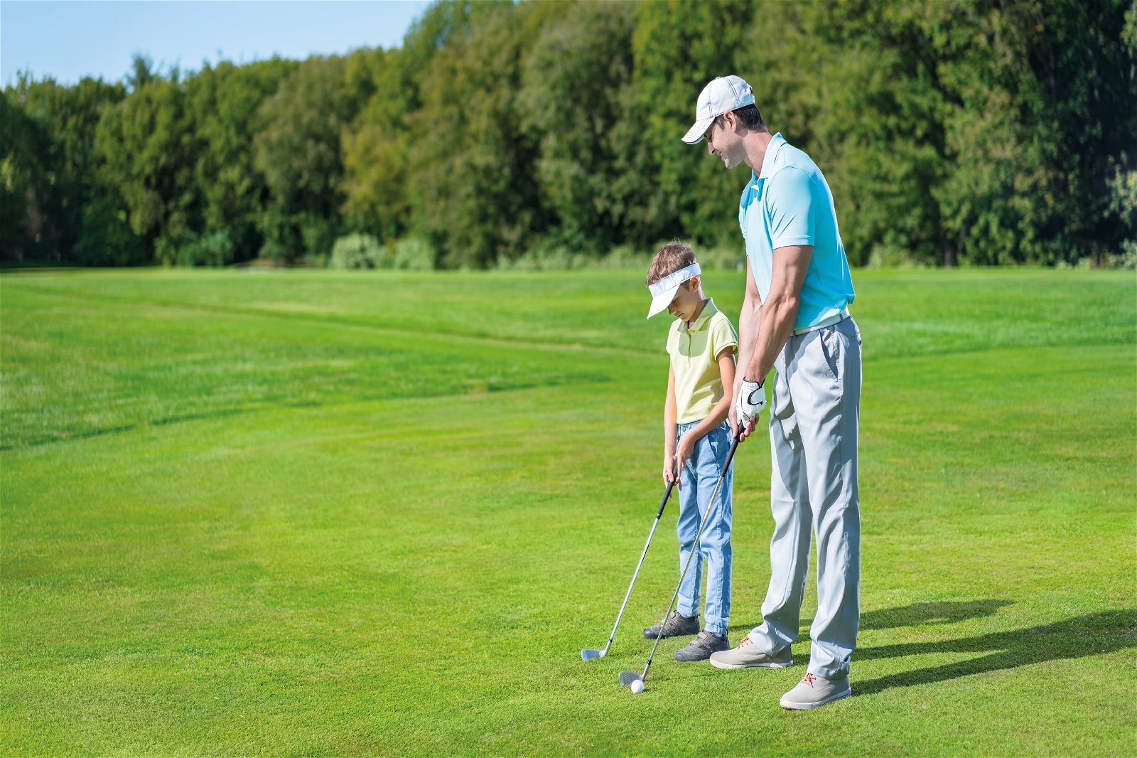 Father and son putting on golf course