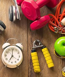 analog alarm clock next to workout equipment