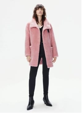 a model in a pink coat and black leggings