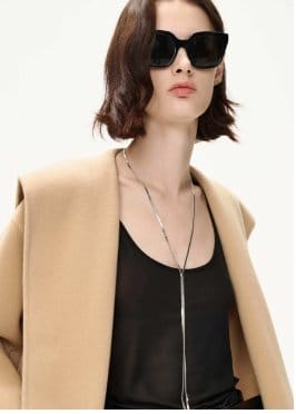 a woman wearing sunglasses and a coat