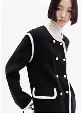 a model wearing a black jacket with white buttons