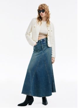 a woman in a denim skirt and a white jacket