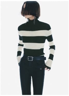 a woman wearing a striped sweater and black jeans