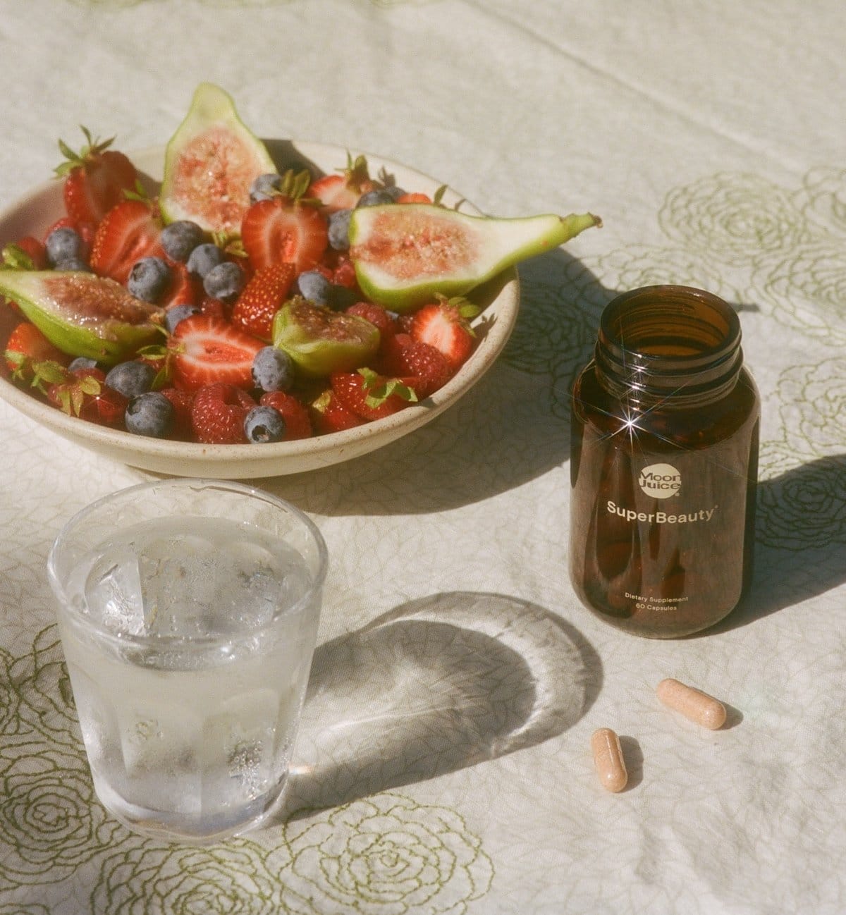 SuperBeauty bottle next to a plate of fruit