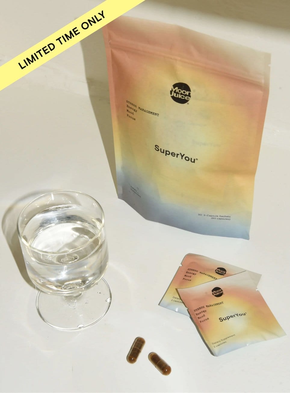 SuperYou sachet next to glass of water and SuperYou pills