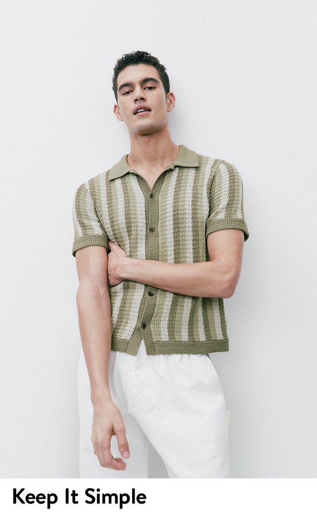 A model wearing a green striped knit shirt.