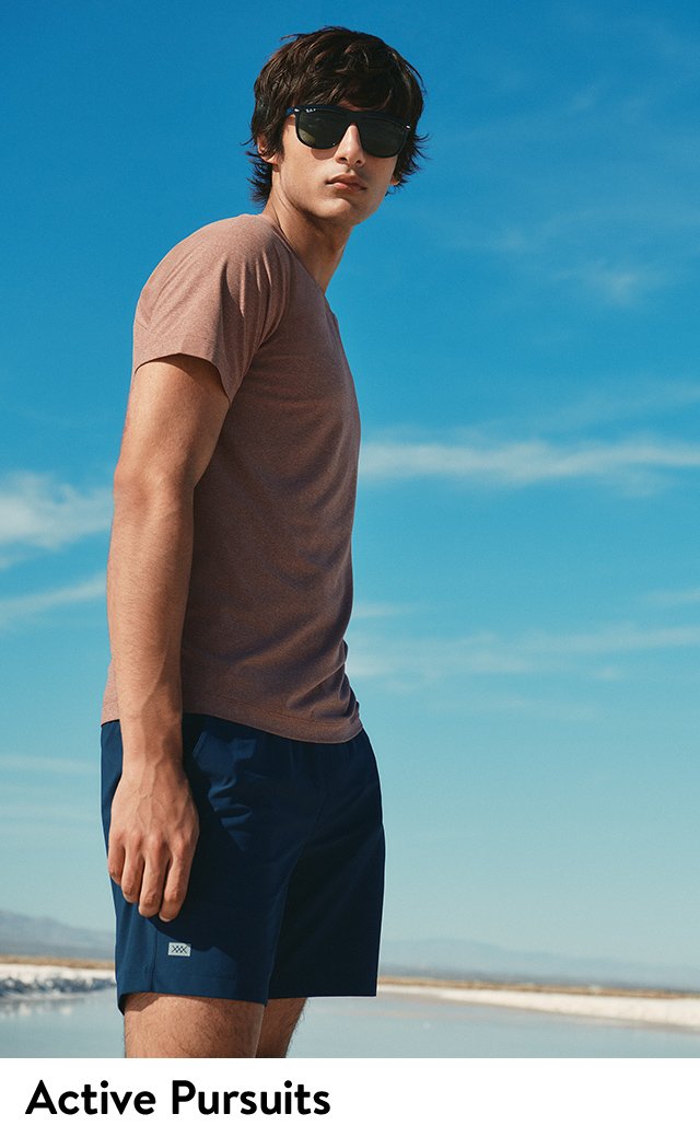 A model wearing a T-shirt and shorts against a blue sky.