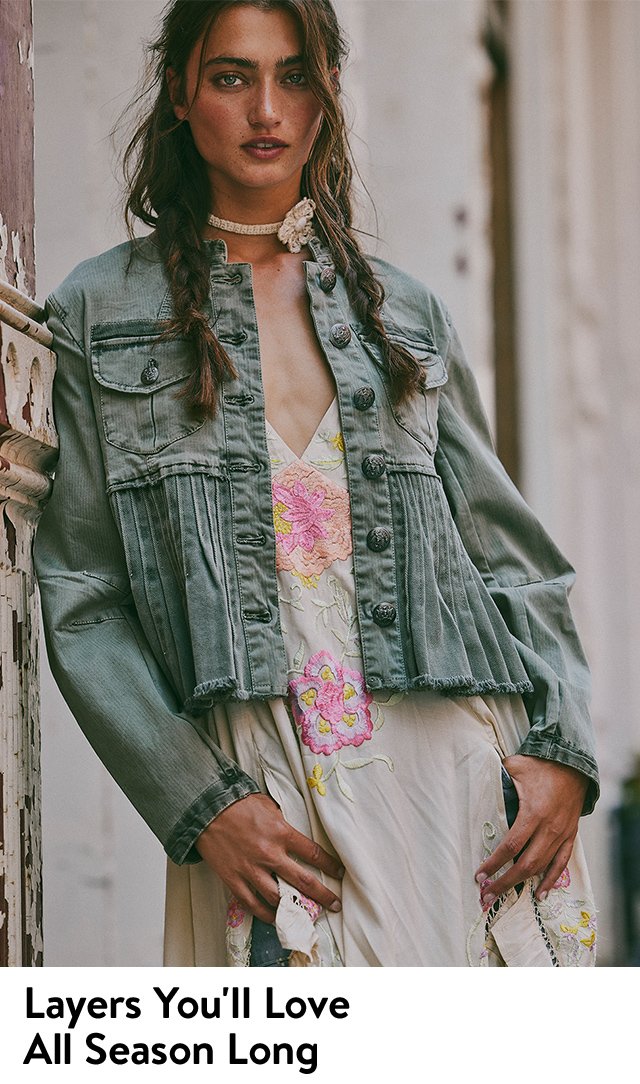 A woman wearing a denim jacket, floral top and jeans.