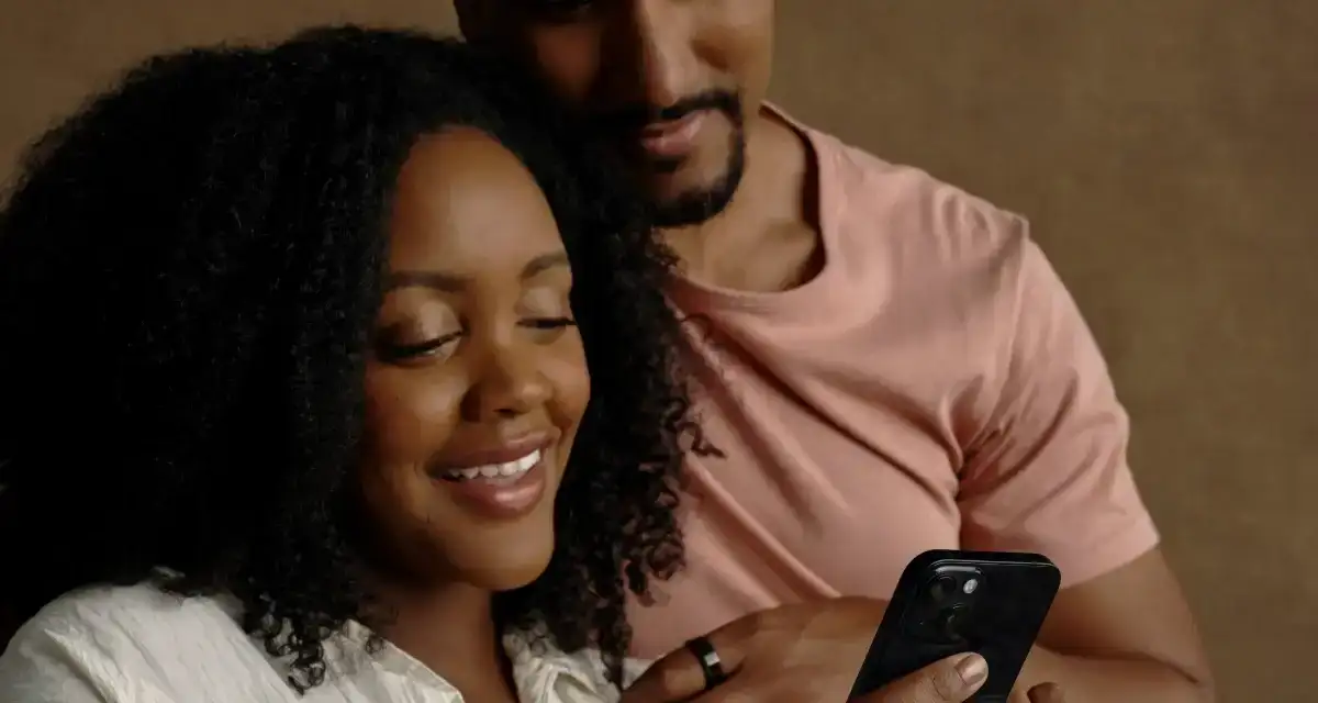 Two people looking at a phone wearing Oura Ring