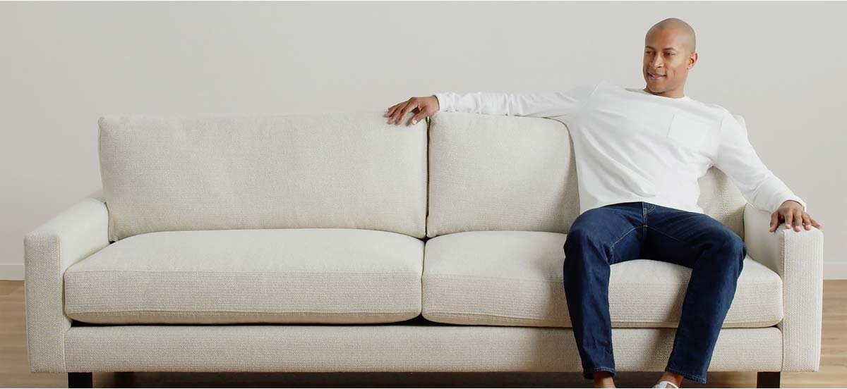 Person sitting on right side of a couch
