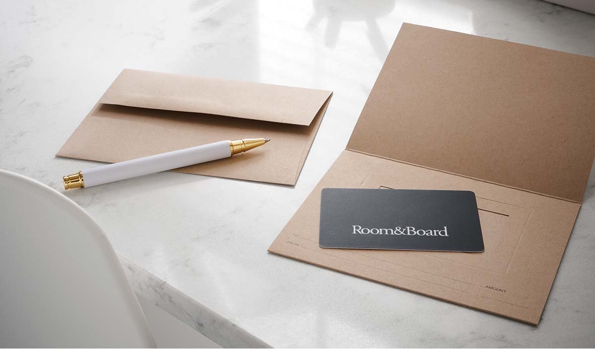 Room & Board gift card in next to envelope and a pen