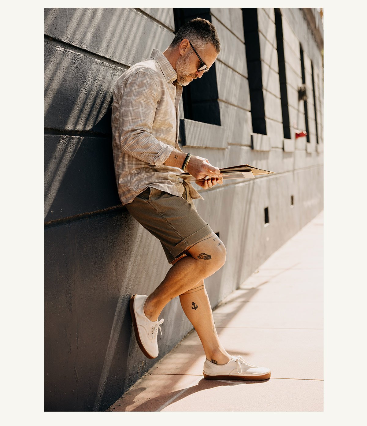 fit model leaning against the wall wearing The Matlow Short in Baked Soil Herringbone