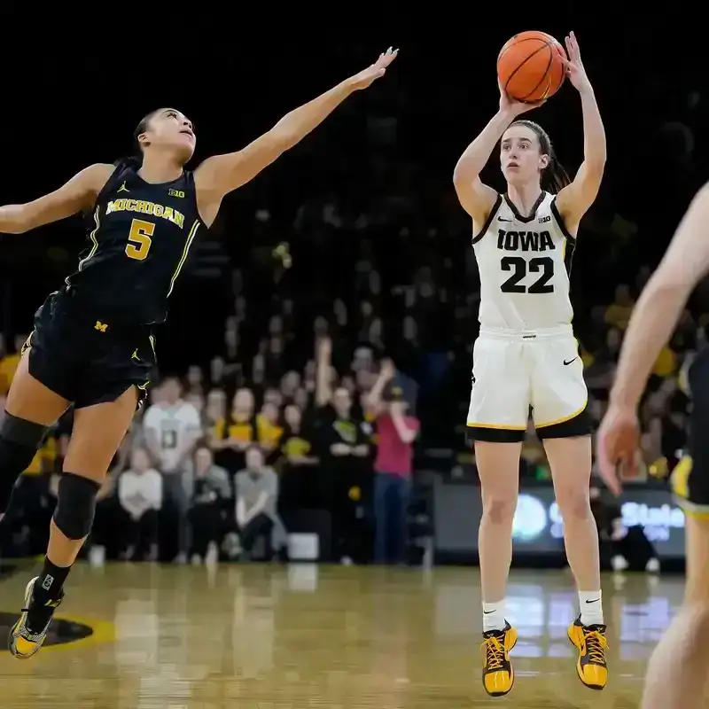 A photo of Caitlin Clark shooting a three-pointer as Laila Phelia is late to defend, during a N.C.A.A. basketball game.