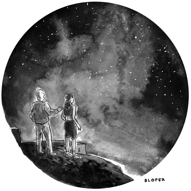 Two people stand at the edge of a cliff as they look up at the universe’s stars. 