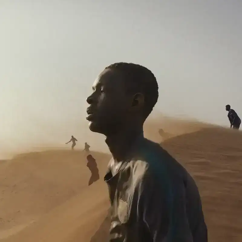 People standing on sand dunes.