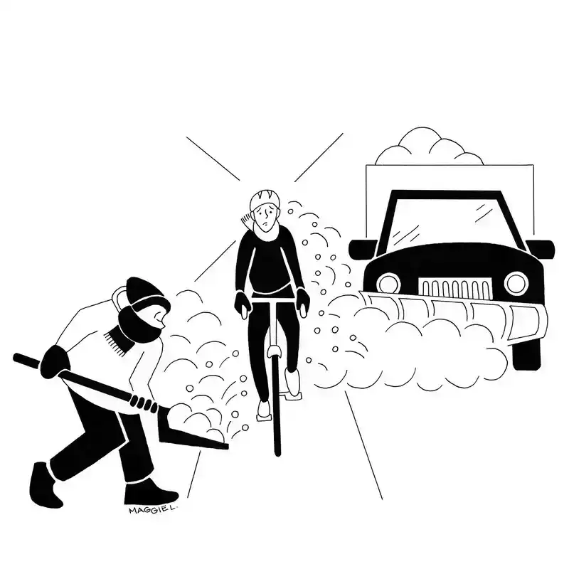 A worried-looking bicyclist pedals down the street. In the background is a snowplow, and in the foreground is a person with a shovel; both heap snow into the bicycle lane.