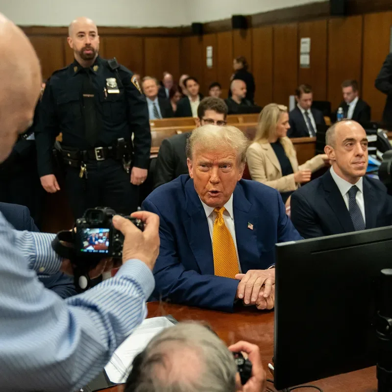 A photo of Donald Trump sitting at a table and scowling, in a Manhattan criminal courtroom.