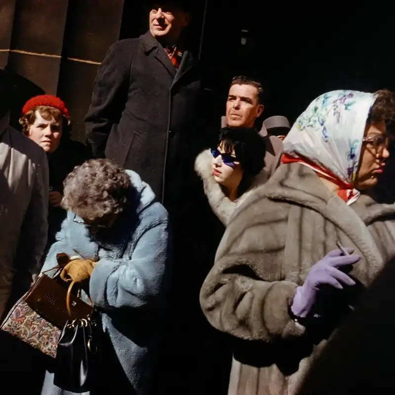A crowd of people wearing coats on the street.