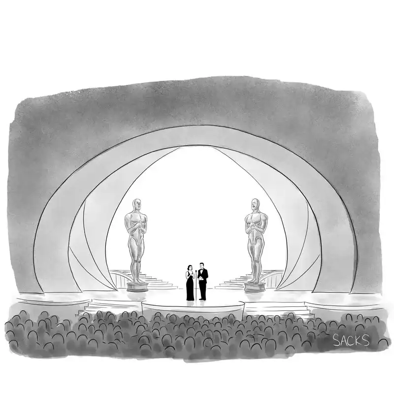 Two Oscar presenters stand onstage, in front of a microphone, at the Academy Awards.