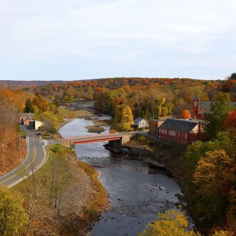 Photograph of a small town in the Hudson Valley during fall with a river running in the middle 
