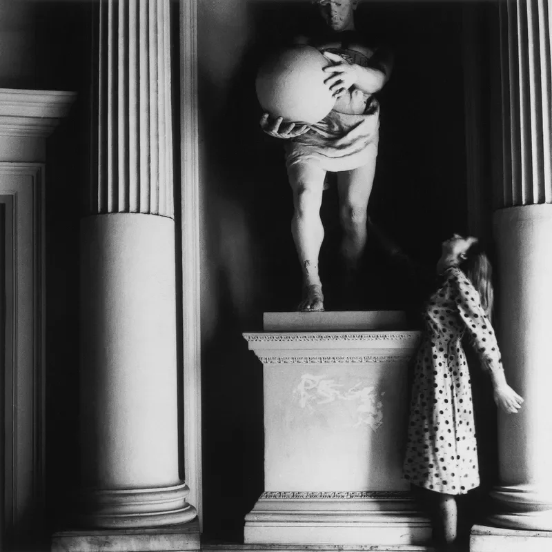 A person looking up at a sculpture.