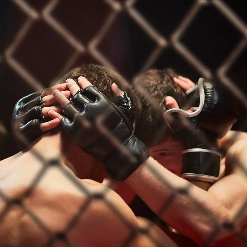 Two UFC fighters holding each other's heads very close. 