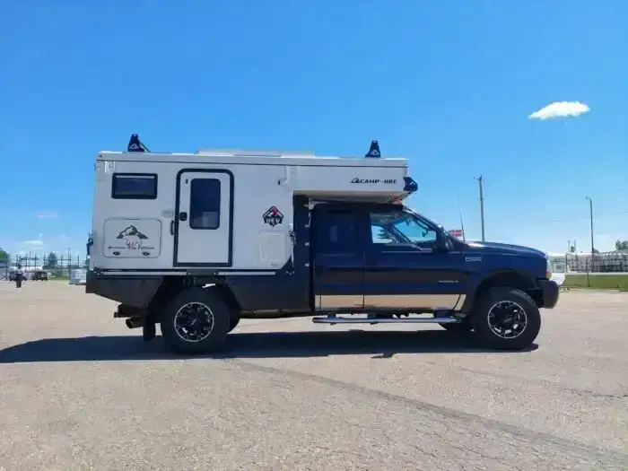 White truck camper on the back of a black truck